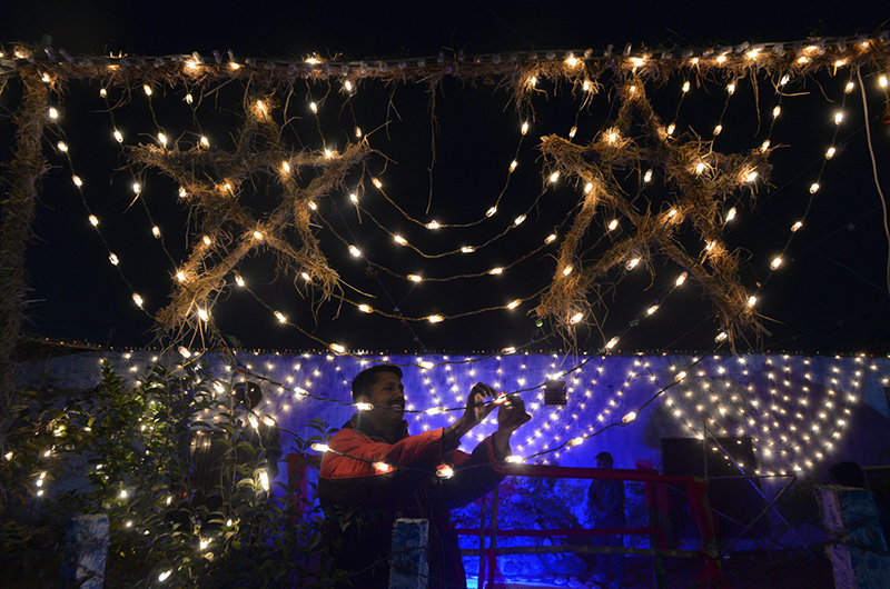 A man decorating lights ahead of Christmas celebrations at 100 quarters
