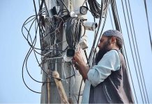A worker busy in repairing security cameras at different places in the city