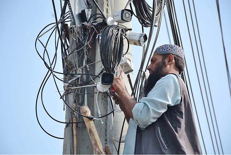 A worker busy in repairing security cameras at different places in the city