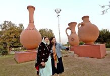 Women taking selfie with cell phone while visiting Jinnah Park