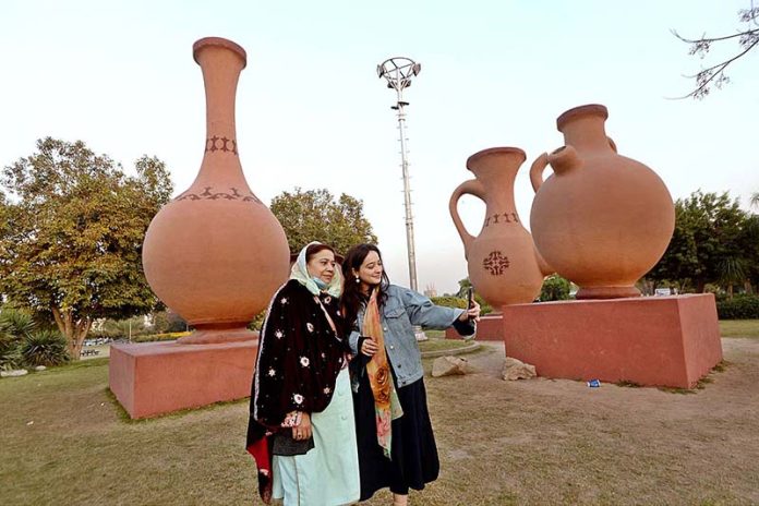 Women taking selfie with cell phone while visiting Jinnah Park