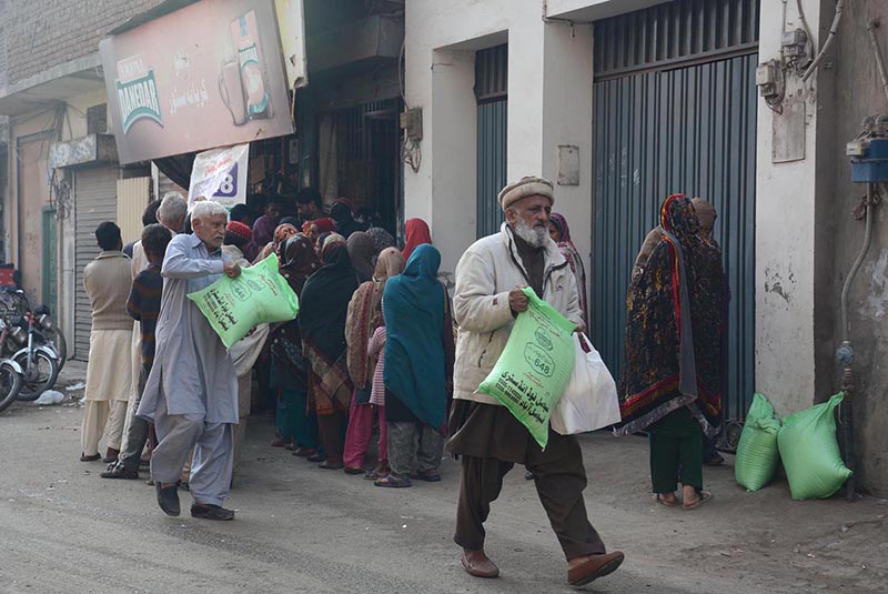 People standing in queue and waiting for their turn to purchase flour bags on subsidized rates