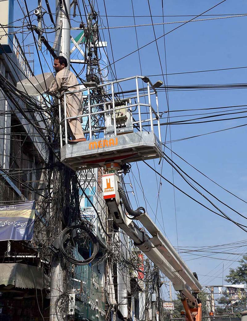 A Metropolitan Corporation official is repairing the street light at DC Road.