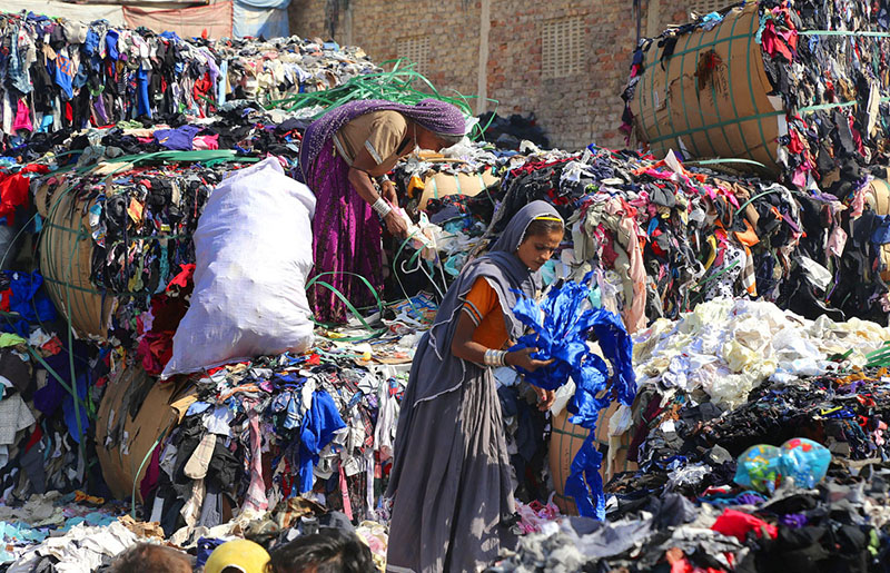 Female labourer sorting old clothes at Site Area