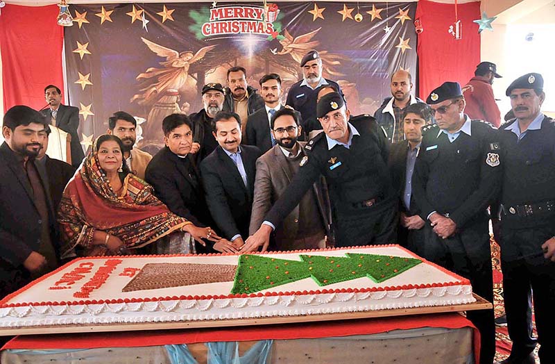 Christian community members along with security personnel cutting cake on Christmas day at Fatima Church F-8.