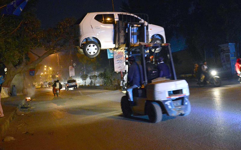 Traffic warden removing wrongly parked vehicle at Court Road