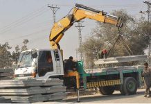 Laborers working on construction work of 9th Avenue Flyover at IJP Road during development work in the city