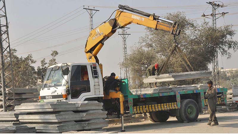 Laborers working on construction work of 9th Avenue Flyover at IJP Road during development work in the city