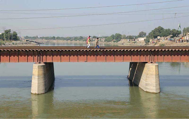 Local people walk on Railway Bridge for crossing the phuleli canal