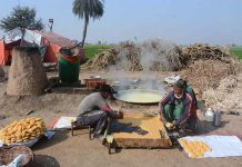 Farmers boiling sugarcane juice to preparing traditional sweet item “Gur” at Millat Road