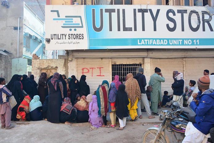 People standing in a queue outside Utility Store to purchase grocery items on subsidized rates at Latifabad