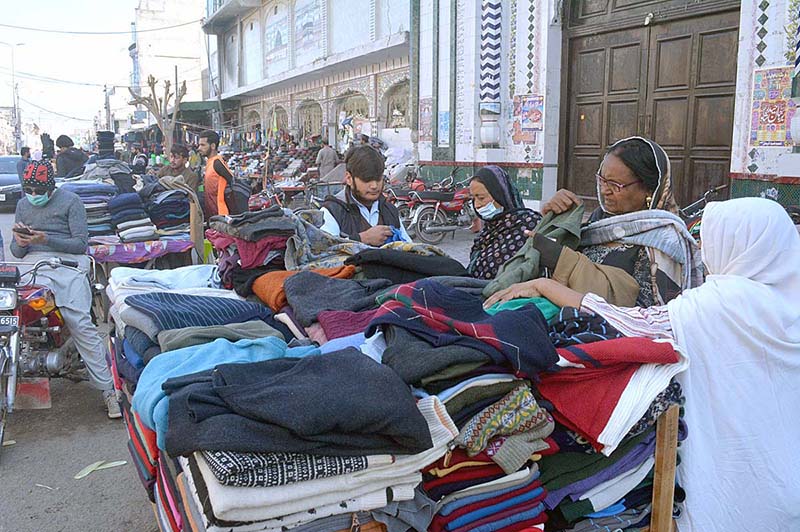 People purchasing old shoes from a vendor at Bara Bazar