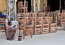 A worker busy in giving final touches the wooden chairs at Makrani Para Road