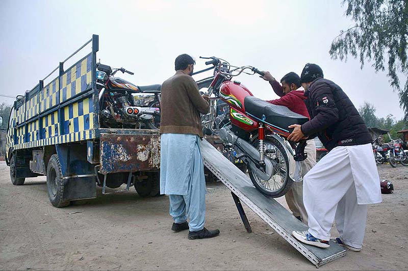 Workers unloading challan issued motorcycles from a truck due to incomplete documents at Gulbahar Traffic Terminal