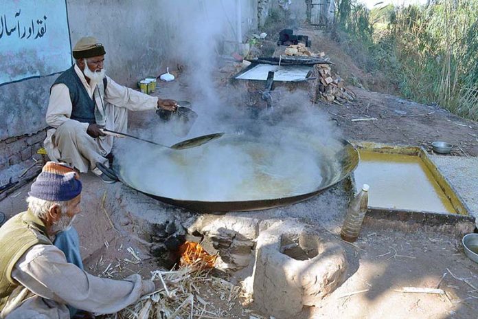 Farmers busy in boiling sugarcane juice to preparing traditional sweet item “Gur” at Sargodha Bypass