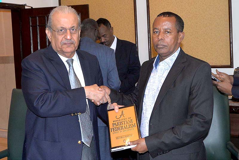 Senator Mian Raza Rabbani presenting a book to Ahmad Osman Aden, Deputy Minister of Interior Galmudug State