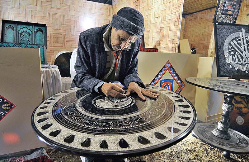 An artisan demonstrating his skills at a stall during Folk Festival ‘Lok Mela’ 2022 at Lok Virsa