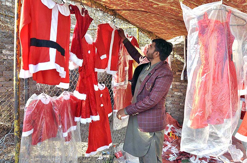 A vendor displaying Santa Claus outfits to attract the customers in connection with upcoming Christmas celebrations