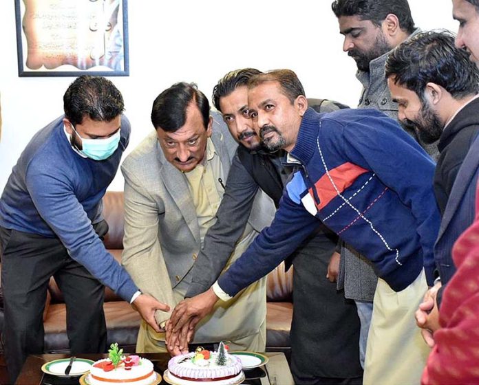 SAPM/Mos for Industries and Production Tasneem Ahmed Qureshi cutting cake in the honour of Christian employees of the ministry