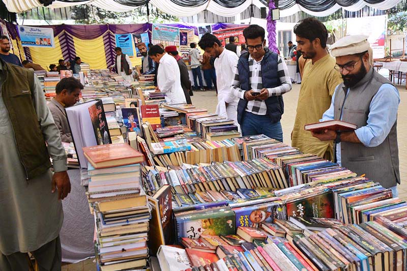 Visitors searching and selecting books at books stall during 8th edition of Ayaz Melo organized by Khanabadosh Writers Café at Sindh Museum.