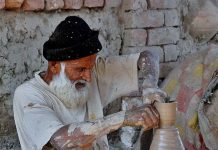 Senior artist making traditional pots at his workplace