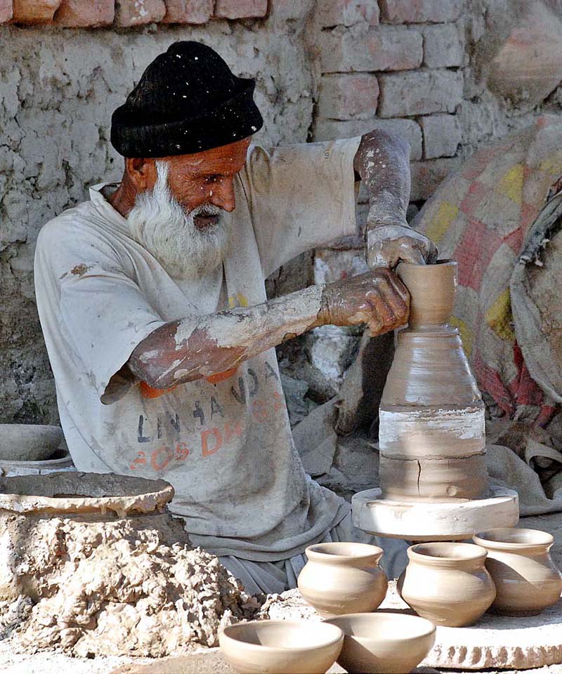 Senior artist making traditional pots at his workplace