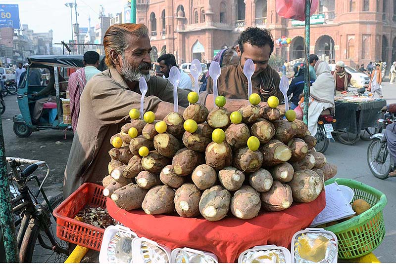 Vendor displaying roasted sweet potatoes (Shakarkandi) to attract the customers