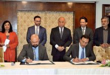 Securities and Exchange Commission of Pakistan representative signing MOU with Pakistan Software Export Board representative during Pakistan Regulatory Modernization Initiative Ceremony in a local hotel