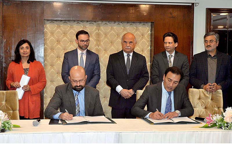 Securities and Exchange Commission of Pakistan representative signing MOU with Pakistan Software Export Board representative during Pakistan Regulatory Modernization Initiative Ceremony in a local hotel