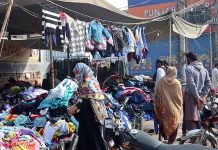 People selecting and purchasing second hand clothes from a Landa Bazar