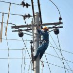 FESCO worker removing faults from electricity line on an electric pole