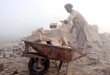 A labourer busy in his work as thick fog engulfs the city at morning time