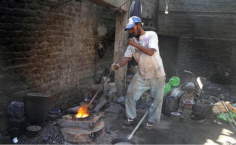 A worker melting the metal at his work place