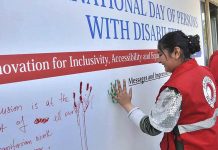 Participants are imprinting their hand marks during the "International Day of Persons with Disabilities 2022" at PRCS HQ