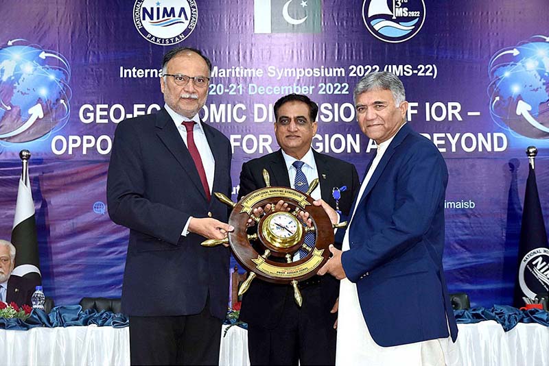 Chairman NIMA Advisory board Admiral (Retd) Muhammad Asif Sandila NI(M) giving souvenir to Federal Minister for Planning Development and Special Initiative Ahsan Iqbal during International Maritime Symposium 2022 at Bahria University