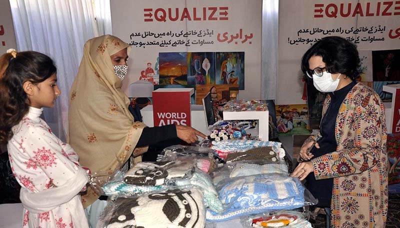 Women displaying exhibition stall during the seminar on "Commemoration of World AIDS Day 2022" organized by Ministry of National Health Services, Regulations and Coordination and UNAIDS & UN partners.