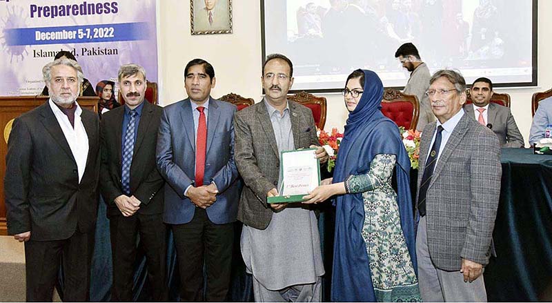 Federal Minister for Science and Technology Agha Hassan Baloch distributes shield to Position Holder poster presenter during a conference on Epidemic & Pandemic Preparedness organized by Pakistan academy of Science