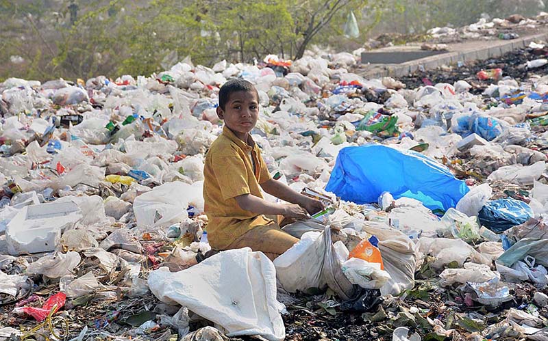 A gypsy child searching valuables from the heap of garbage