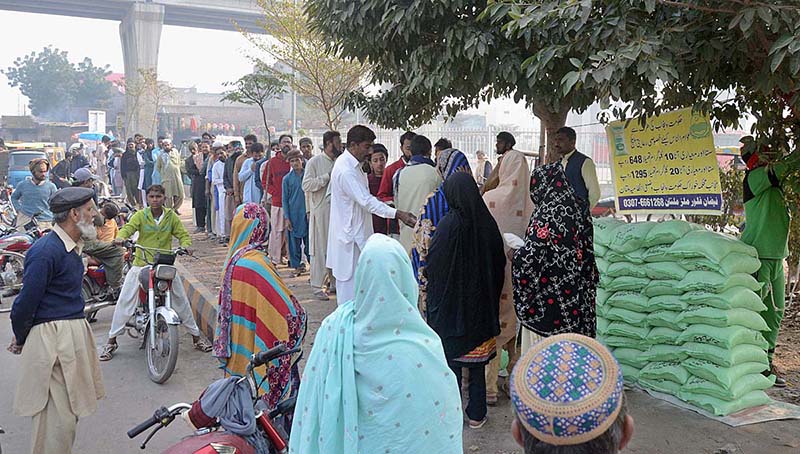 People standing in a long queue for purchase flour bag in controlled rate from stall.