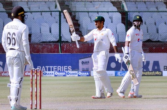 Pakistan's Sarfraz Ahmed gestures with Imam-UL-Haq after scoring a half-century (50 runs) during the fifth and final day of the first Test Cricket Match between Pakistan and New Zealand at the National Stadium