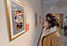 A girl viewing a painting at the art exhibition on "16 Days of Activism Against Gender-Based Violence" at Pakistan National Council of Arts
