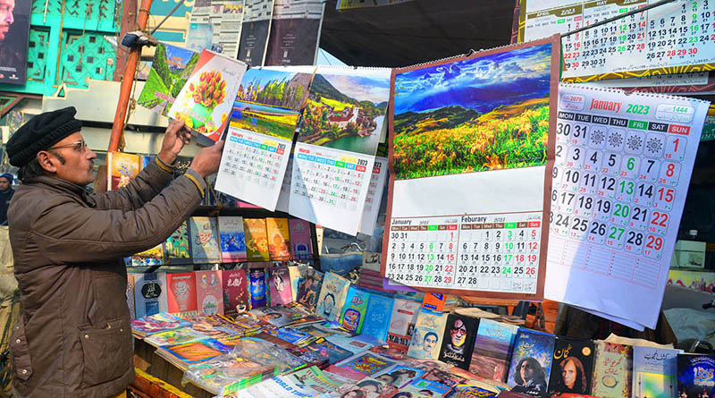 A vendor displaying a New Year advent calendar at a newspaper stall at old Anarkali