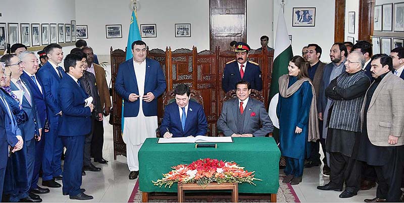 Chairman Mazhilis of the Parliament of Kazakhstan Yerlan Koshanov inscribing his remarks in Visitors Book. Speaker National Assembly Raja Pervez Ashraf is also present on the occasion
