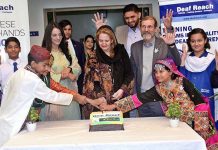 First Lady Samina Arif Alvi cutting cake at Deaf Reach Schools Training Centers