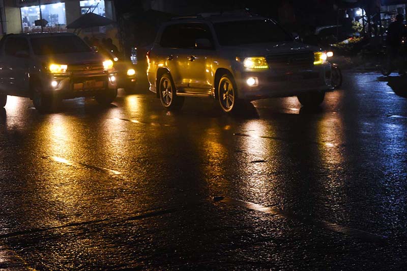 A view of vehicles light reflection on road after rain that experienced in the city.