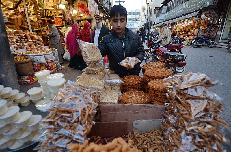 A vendor making flower garlands for customers at Fawara Chowk