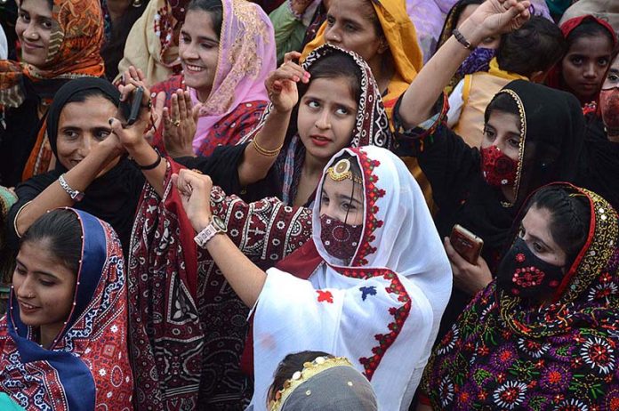 Girls enjoy on the cultural music during the occasion of Sindhi Cultural Day outside the Karachi Press Club.