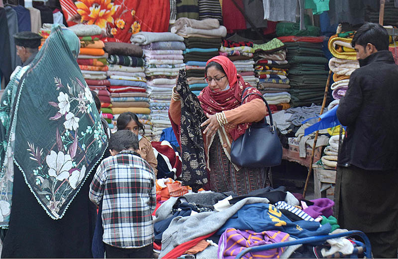 Women purchasing warm winter clothes at a roadside stall