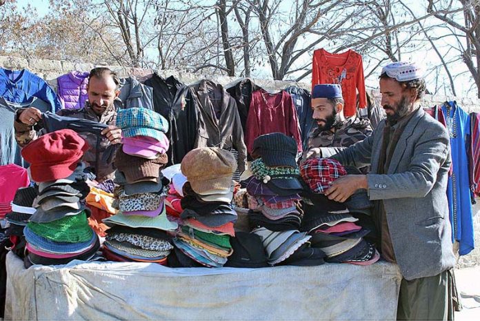 Vendor selling warm cap for winter season on Railway Station Road