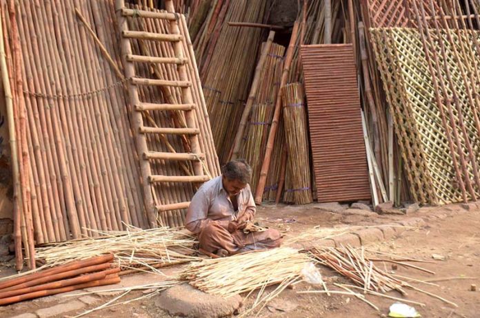 Workers busy in preparing ladder with bamboos at his workplace